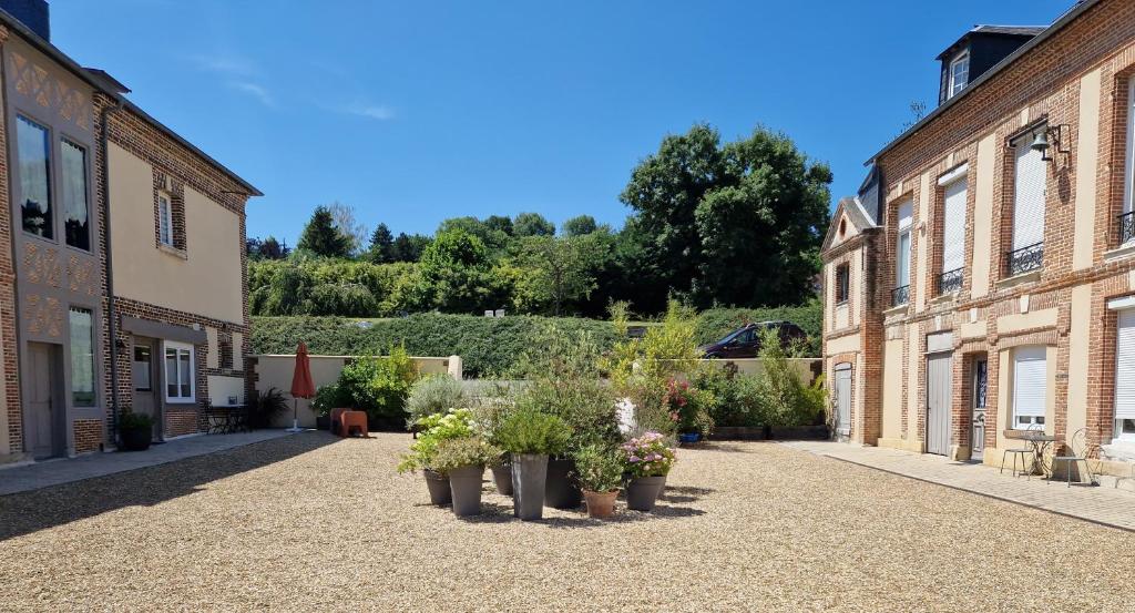 une cour d'un vieux bâtiment avec des plantes en pot dans l'établissement La cour, à Honfleur