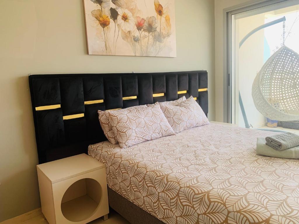 a bedroom with a bed with a black headboard at Élégance et Sérénité Vue Mer Panoramique et Piscine Privée in Agadir