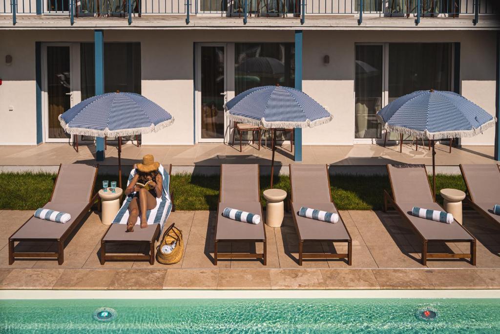 a woman sitting in a chair next to a pool at Złota 34 Karwia in Karwia