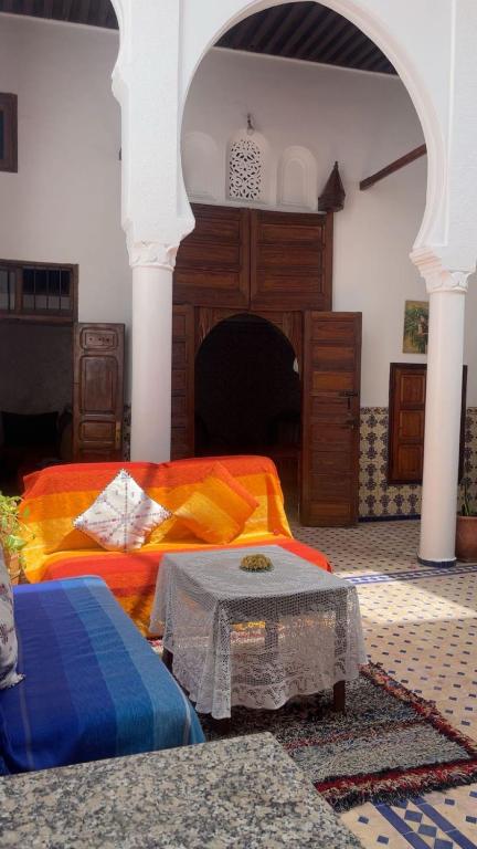 a living room with two beds and a fireplace at Riad Diafa in Oulad Akkou