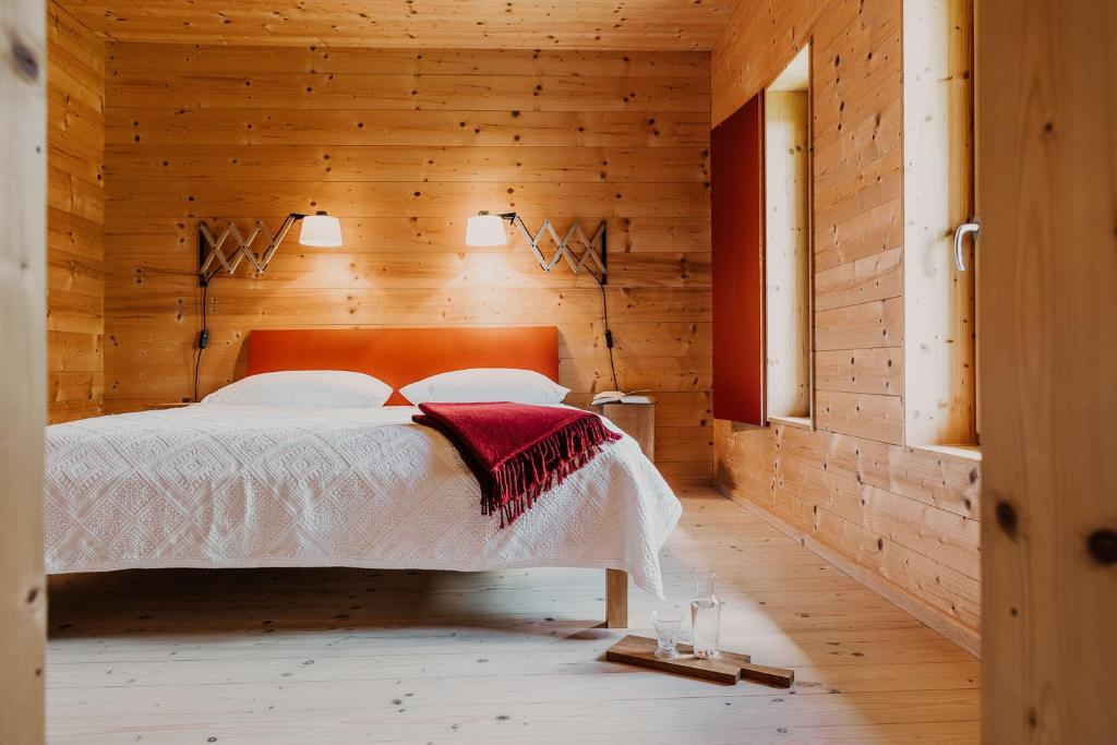 a bedroom with a bed in a wooden wall at Haidl-Madl Ferien und Wohnen in Haidmühle