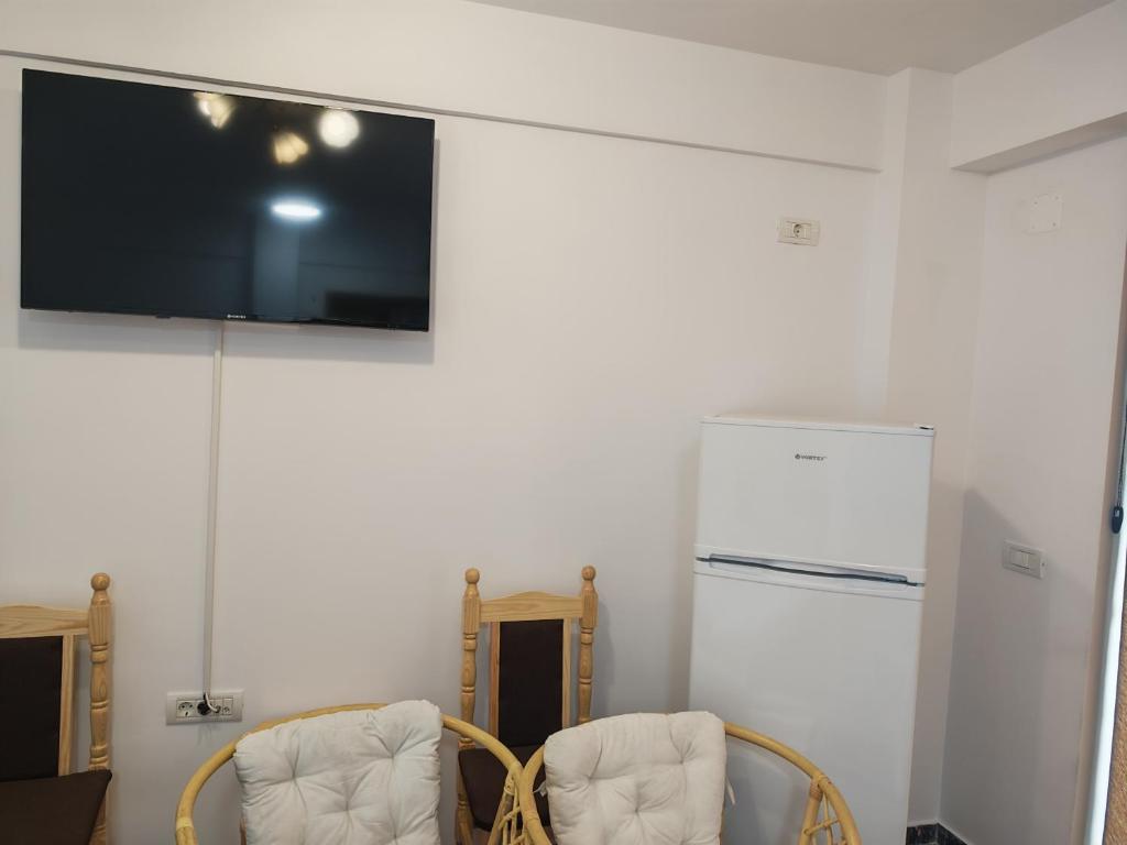 a room with two chairs and a tv on a wall at Seven Studio in Saturn