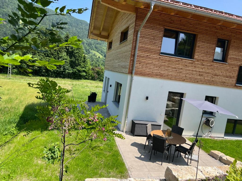 Un patio de una casa con una mesa y sillas. en Servus in der Wiesenstrasse inklusive Chiemgaukarte, en Ruhpolding