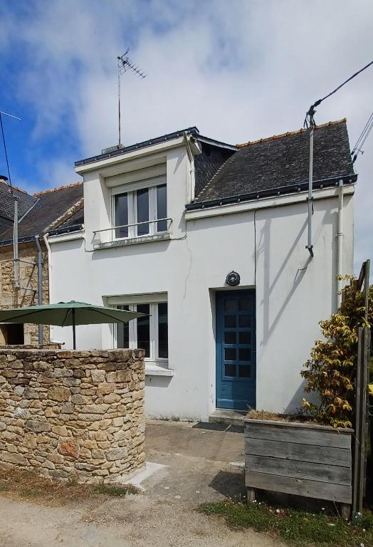 a white house with a blue door and a stone wall at Ty sioul in Crach