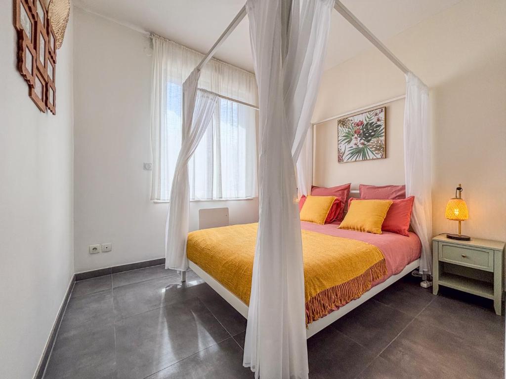 un dormitorio con una cama con dosel en Le Gresset Entre Calme Et Centre D'Amiens, en Amiens