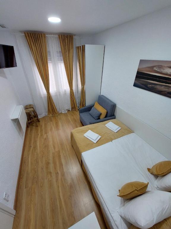 ein kleines Zimmer mit 2 Betten und einem Sofa in der Unterkunft MI CASA ES TU CASA in Hospitalet de Llobregat