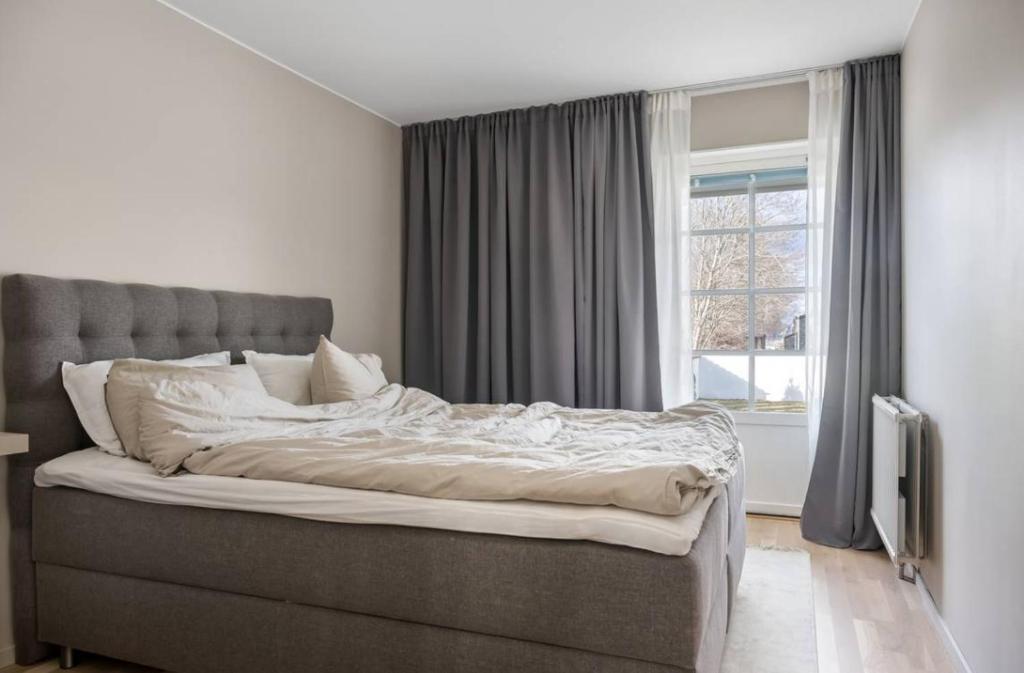 a large bed in a bedroom with a window at Lindö med havsutsikt in Norrköping