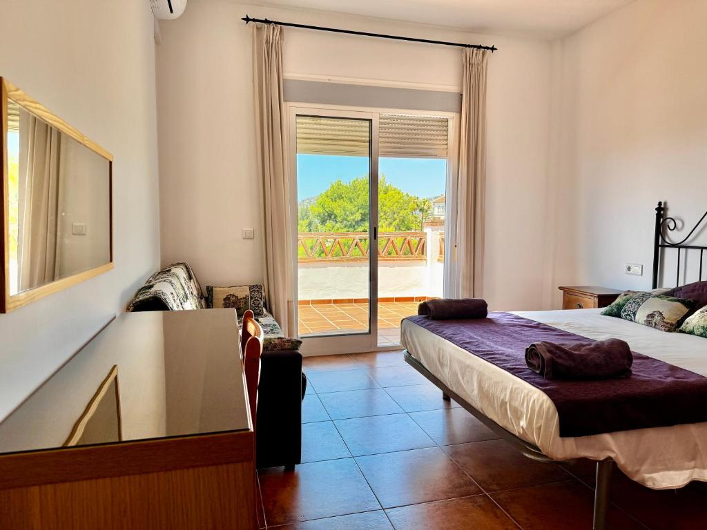 una camera da letto con un letto e vista su un balcone di Villa Pelae a Frigiliana