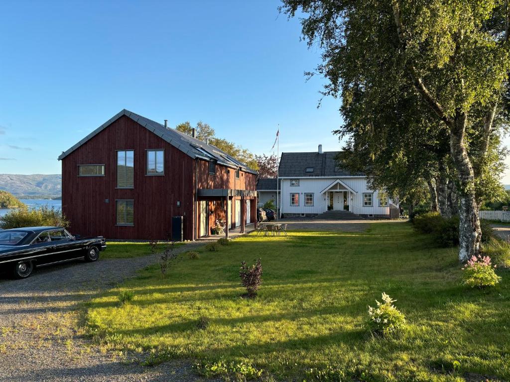 a barn with a car parked in front of a house at Stenegården in Namsos