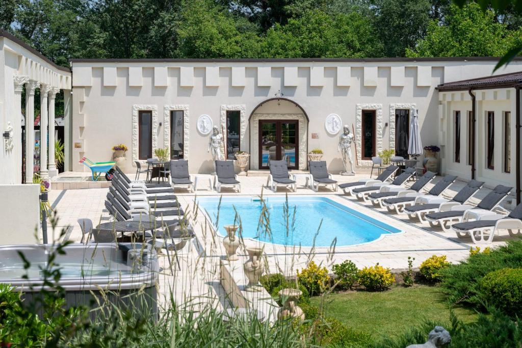 a house with a swimming pool and lounge chairs at La Conac Resort in Hulubeşti