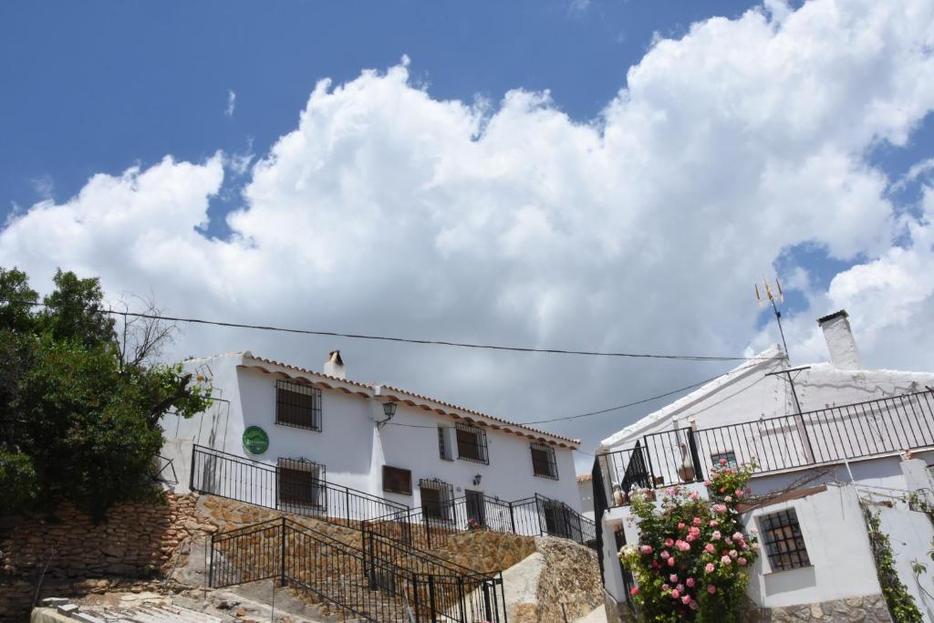 un edificio blanco con flores delante en Casa Rural El Gandulillo, en Castril