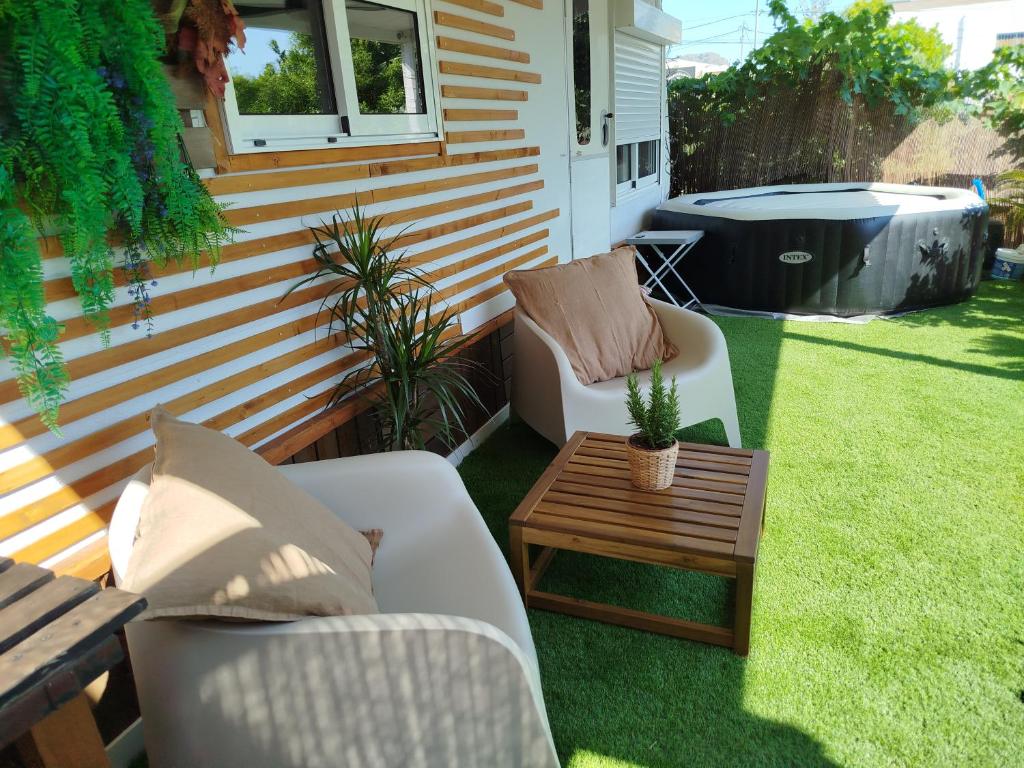 a patio with chairs and a table and a hot tub at Caravana en la huerta in Tiñosa Alta