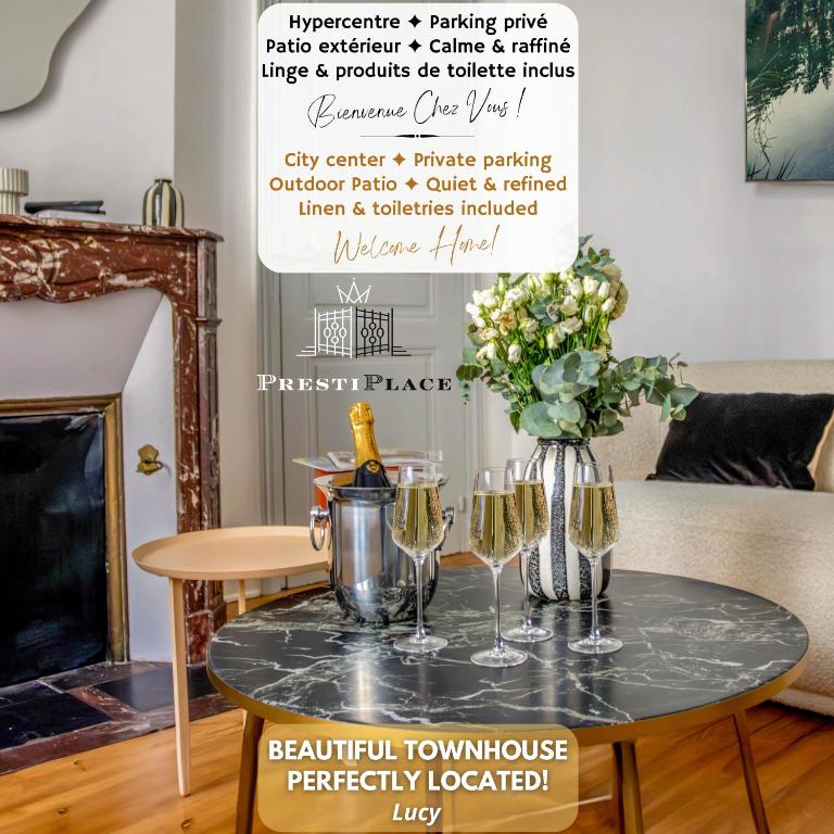 - une table avec des verres à vin et un vase de fleurs dans l'établissement Le Patio des Arts - Parking - By PrestiPlace, à Tours