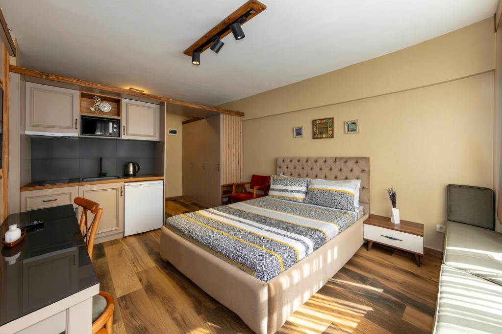 a small bedroom with a bed and a kitchen at Kadıköy Modern Loft & Equipped Stay in Istanbul