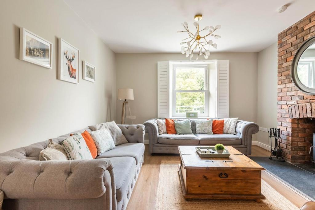 a living room with two couches and a fireplace at River Cottage - Idyllic & Chic Retreat, Wye Valley in Newland