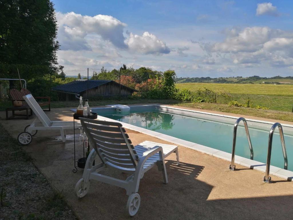 ein Paar Stühle neben einem Pool in der Unterkunft Le gîte des Aubèles in Saint-Félix-de-Lunel