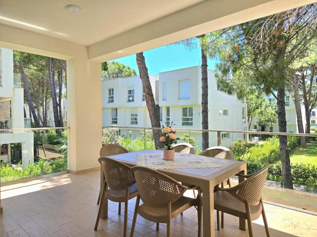 a dining room with a table and chairs on a patio at Holiday Apartment in San Pietro Residence 304 in Lalzit Bay