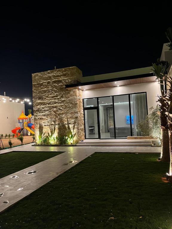 a house at night with a lawn in front of it at فيلا سورا 2 in Buraydah