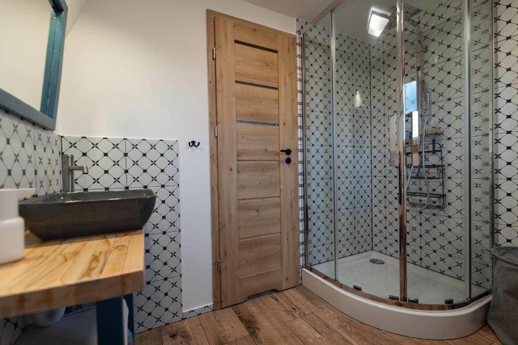 a bathroom with a shower with a glass door at Siódme Niebo domek w górach in Duszniki Zdrój