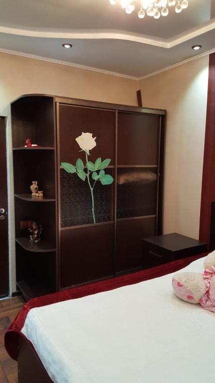 a bedroom with a bed with a flower painted on the wall at Batumi Flat in Itʼkhvisi