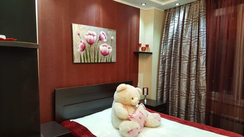 un ours en peluche assis sur un lit dans l'établissement Batumi Flat, à Itʼkhvisi