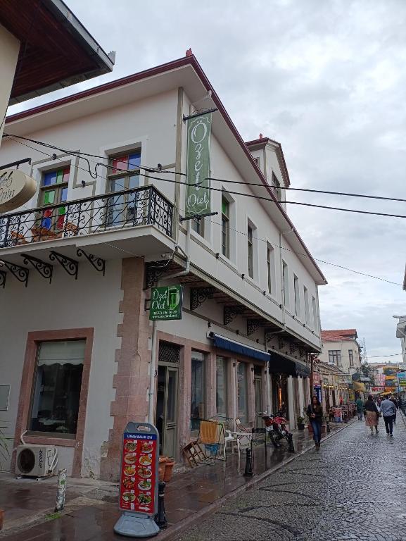 a building on a street with people walking down the street at Özel Otel in Ayvalık