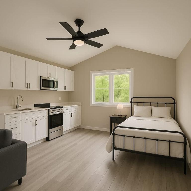 une chambre avec un lit et un ventilateur de plafond dans l'établissement Studio Cottage #8 - Jack Pine, à Gravenhurst