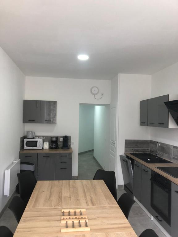 a kitchen with a wooden table and chairs at appt 10 couchages tt confort appt 3 in Laveissière