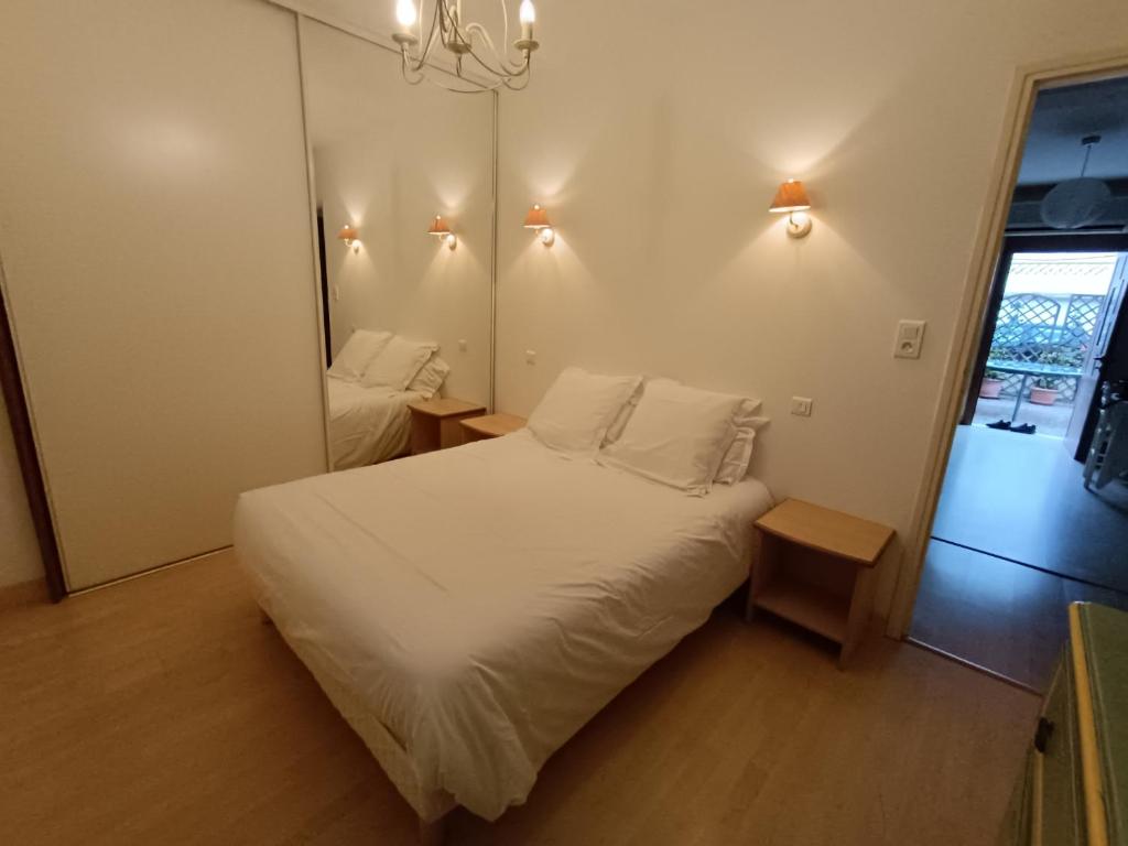 サン・フロランにあるLe cœur de saint Florentの白いベッドと鏡のある寝室