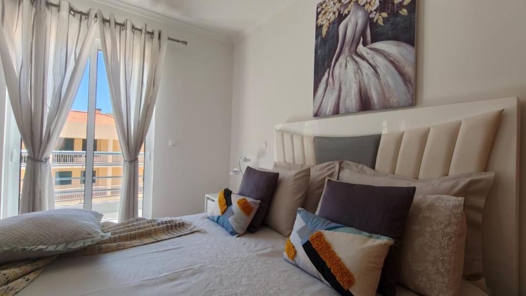 a bedroom with a bed with pillows and a window at Apartamento Luar in Ribeira Brava