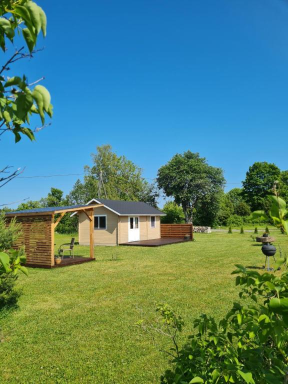 a house in the middle of a grass field at Jootme-Andruse Puhkemaja in Kuressaare