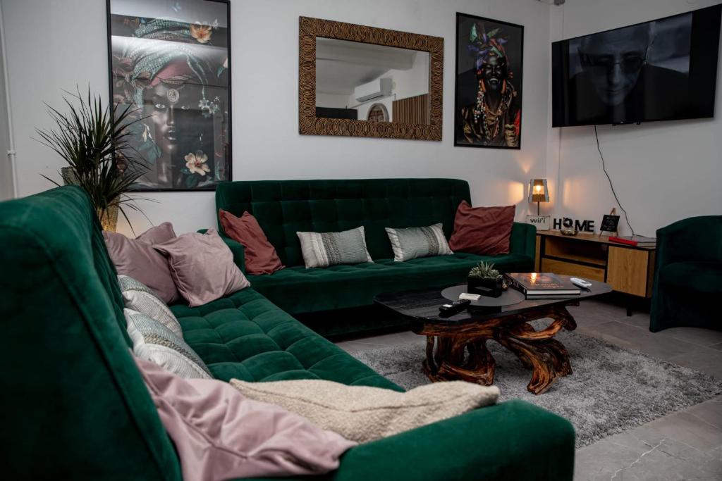 a living room with a green couch and a table at Studio '98 Apartments broj 31 in Sisak
