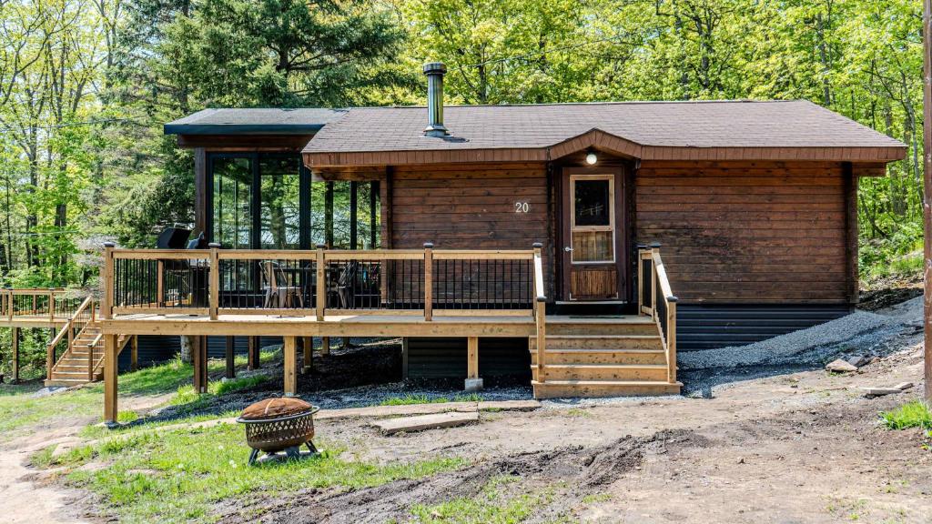 a log cabin with a porch and a deck at Lake Muskoka 3-bedroom Cottage - Pier 100 #20 in Port Carling