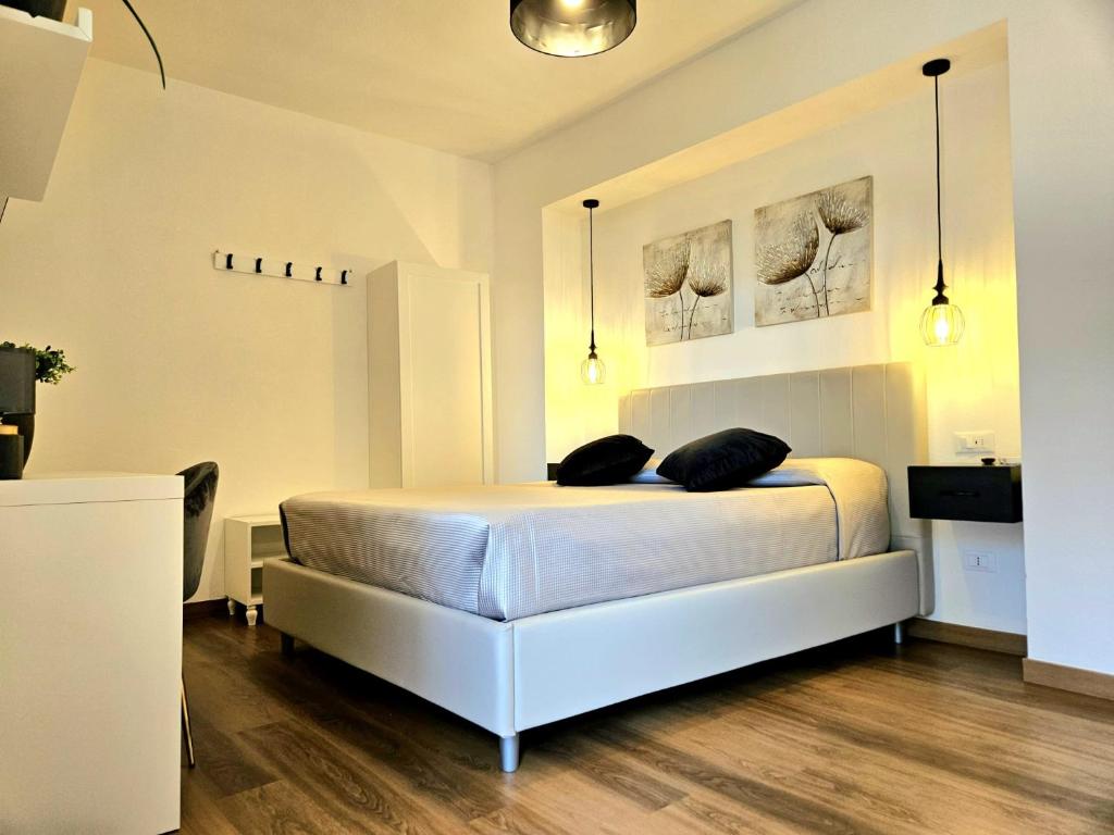 une chambre avec un lit blanc avec deux oreillers dessus dans l'établissement N'Est - Camere di design in centro storico a Orosei, à Orosei