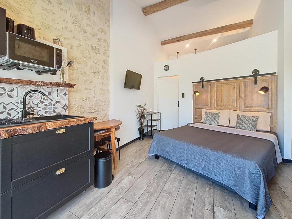 a bedroom with a bed and a desk in it at L inarretable studio independant in Cézac