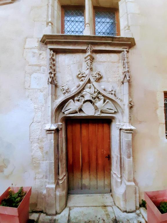 une porte en bois sur le côté d'un bâtiment dans l'établissement La Demeure Trousseau - Hypercentre historique au calme, à Bourges