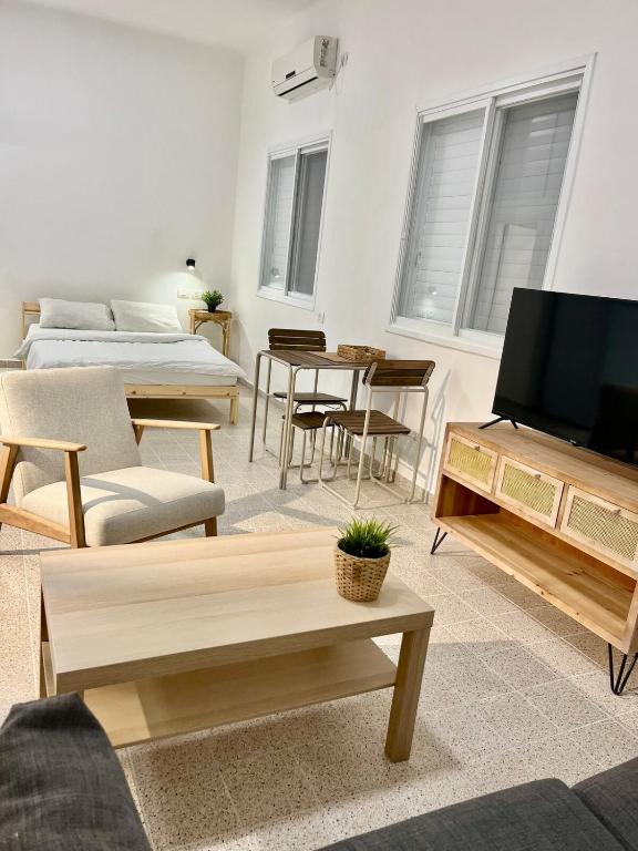 a living room with a tv and a couch at Beautiful studio on Tel Aviv beach in Tel Aviv