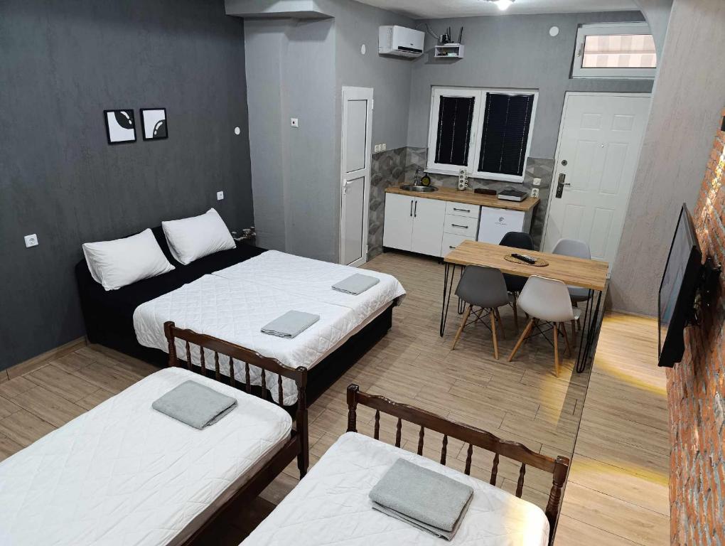 a room with two beds and a table and a desk at Apartment Sekulovski in Ohrid
