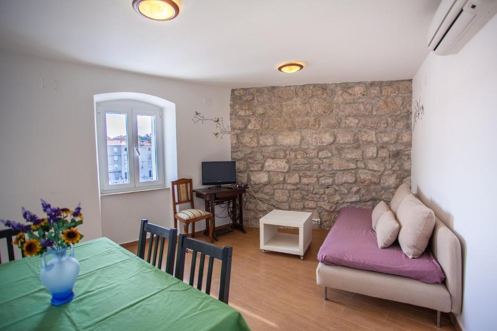 ein Wohnzimmer mit einem Tisch und einem Sofa in der Unterkunft Apartment Pogled na luku in Cres