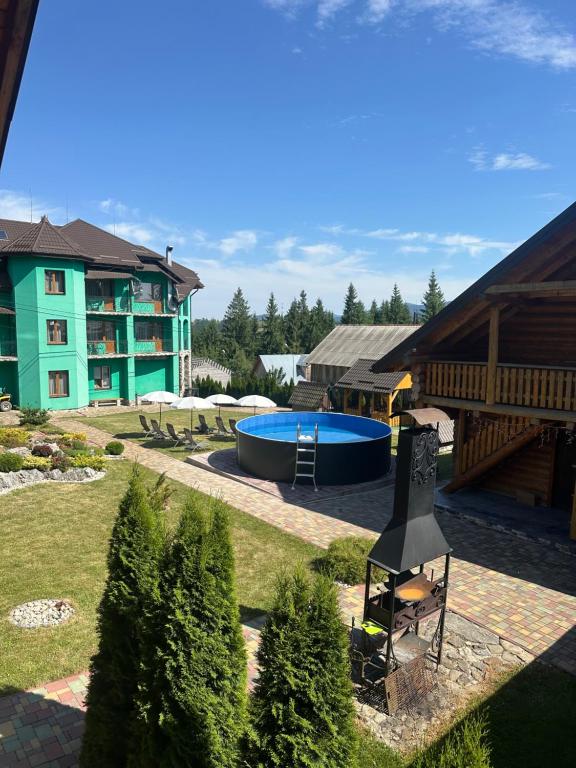 a backyard with a swimming pool and a building at Kisva Hotel in Yablunytsya