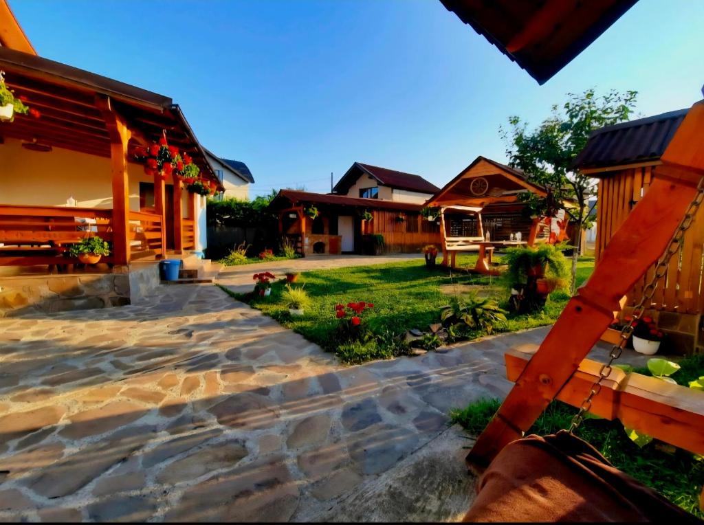 a backyard with a stone walkway and a house at Pensiunea Adriana in Vadu Izei