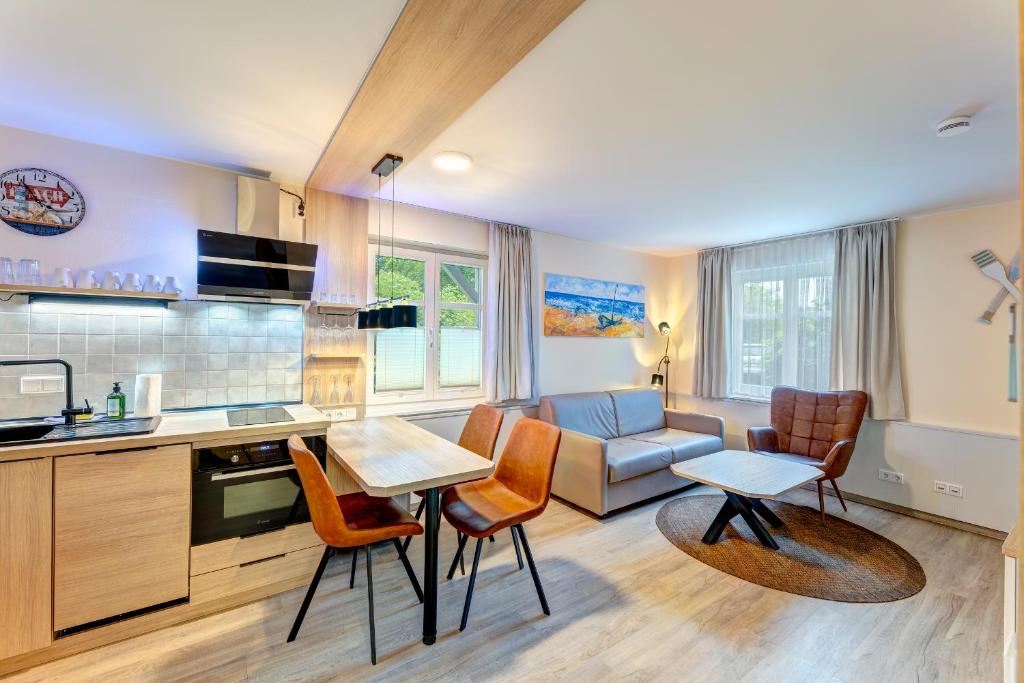 a kitchen with a couch and a table and chairs at Dünenhaus Ückeritz UnserUsedomDe FeWo ca40qm mit Parkplatz direkt am Strand 3I2 in Ueckeritz