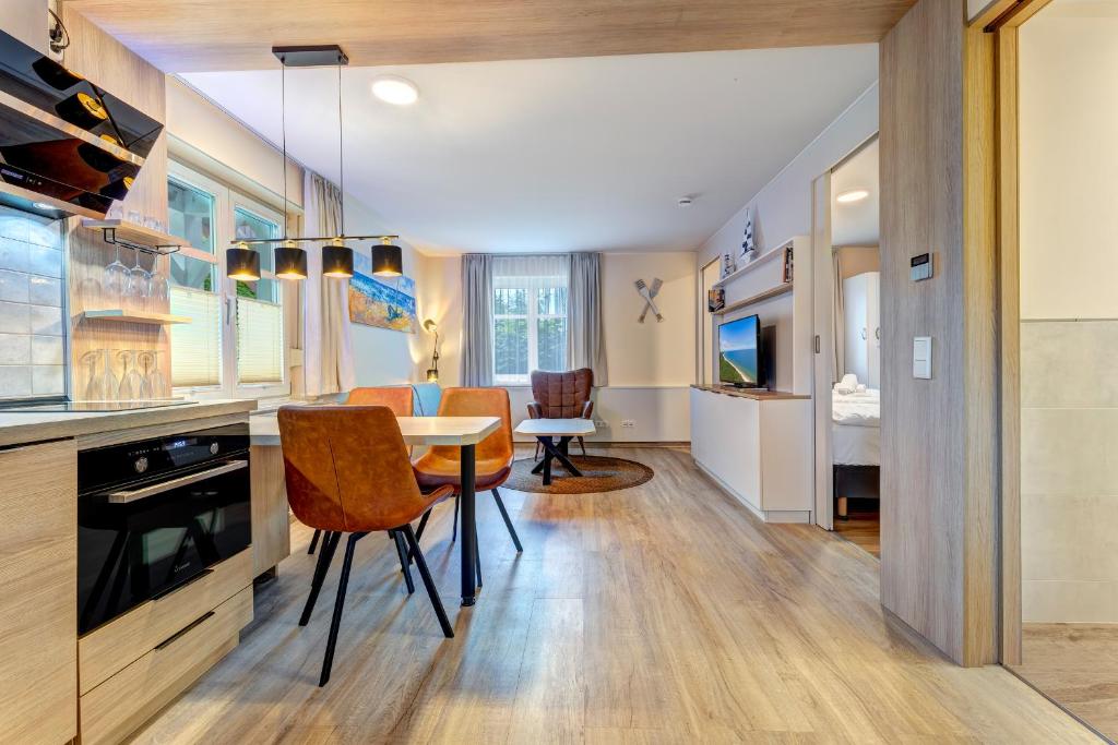 een keuken en eetkamer met een tafel en stoelen bij Dünenhäuser Ückeritz UnserUsedomDe FeWo ca40qm mit Parkplatz direkt am Strand 9I1 in Ueckeritz
