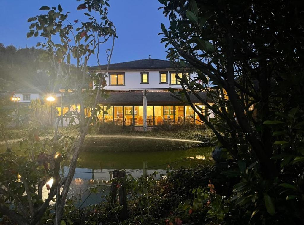 a house in the middle of a pond at night at Le Cavalier Delémont in Soyhières