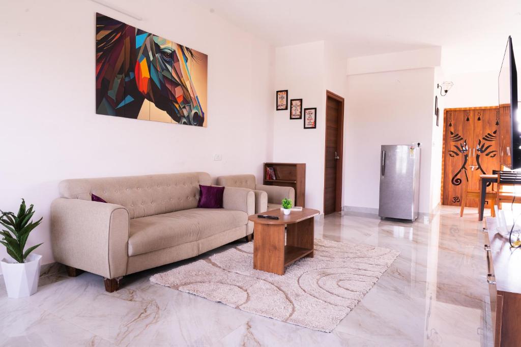 a living room with a couch and a table at Modern Apartment with Balcony - Electronic City in Bengaluru