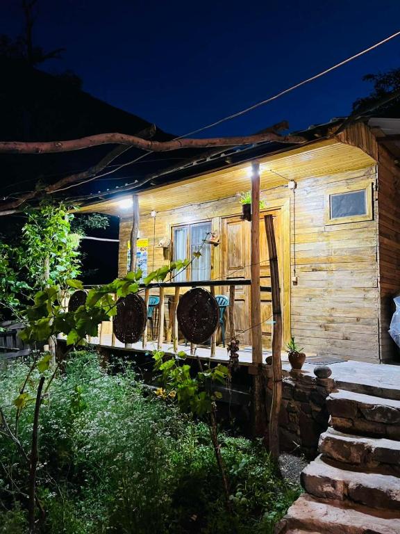 a wooden house with lights on the side of it at Vardzia Chachkari Cottage in Gogasheni
