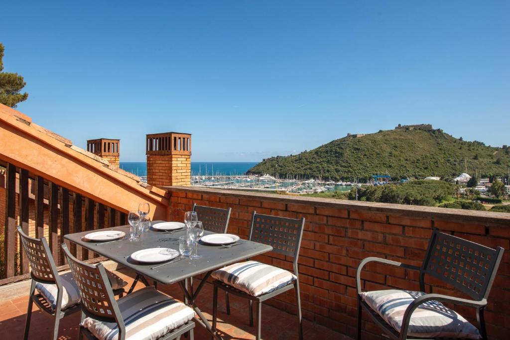 a table and chairs on a balcony with a view of the ocean at Porto Ercole Maison vista mare in Cala Galera