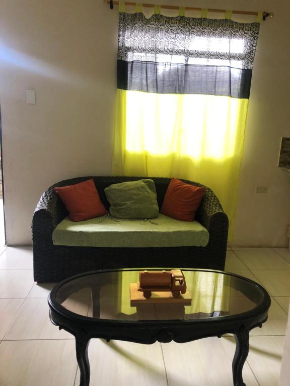 un soggiorno con un divano e un tavolo di vetro di Hospedaje Maluli 07 a Santa Elena