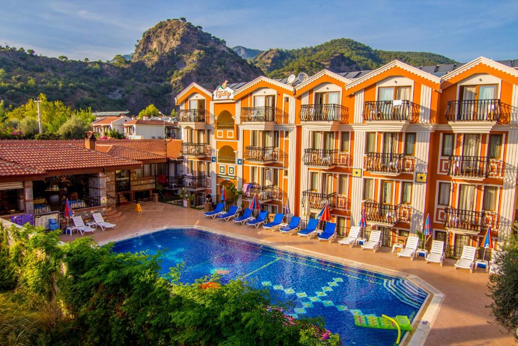 un hotel con piscina frente a un edificio en Magic Tulip Beach Hotel, en Ölüdeniz