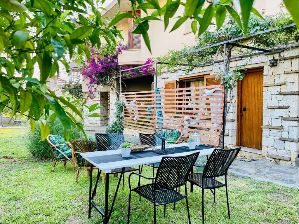 a table and chairs in front of a house at Lavender House Kanali in Kanali